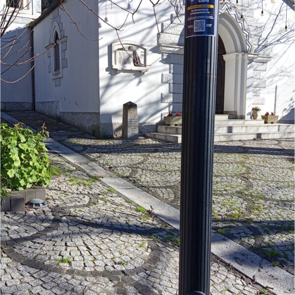 Stone pavement in front of building entrance with black lamppost