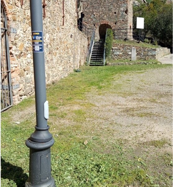 Lampione davanti a un muro di pietra con scala e prato verde