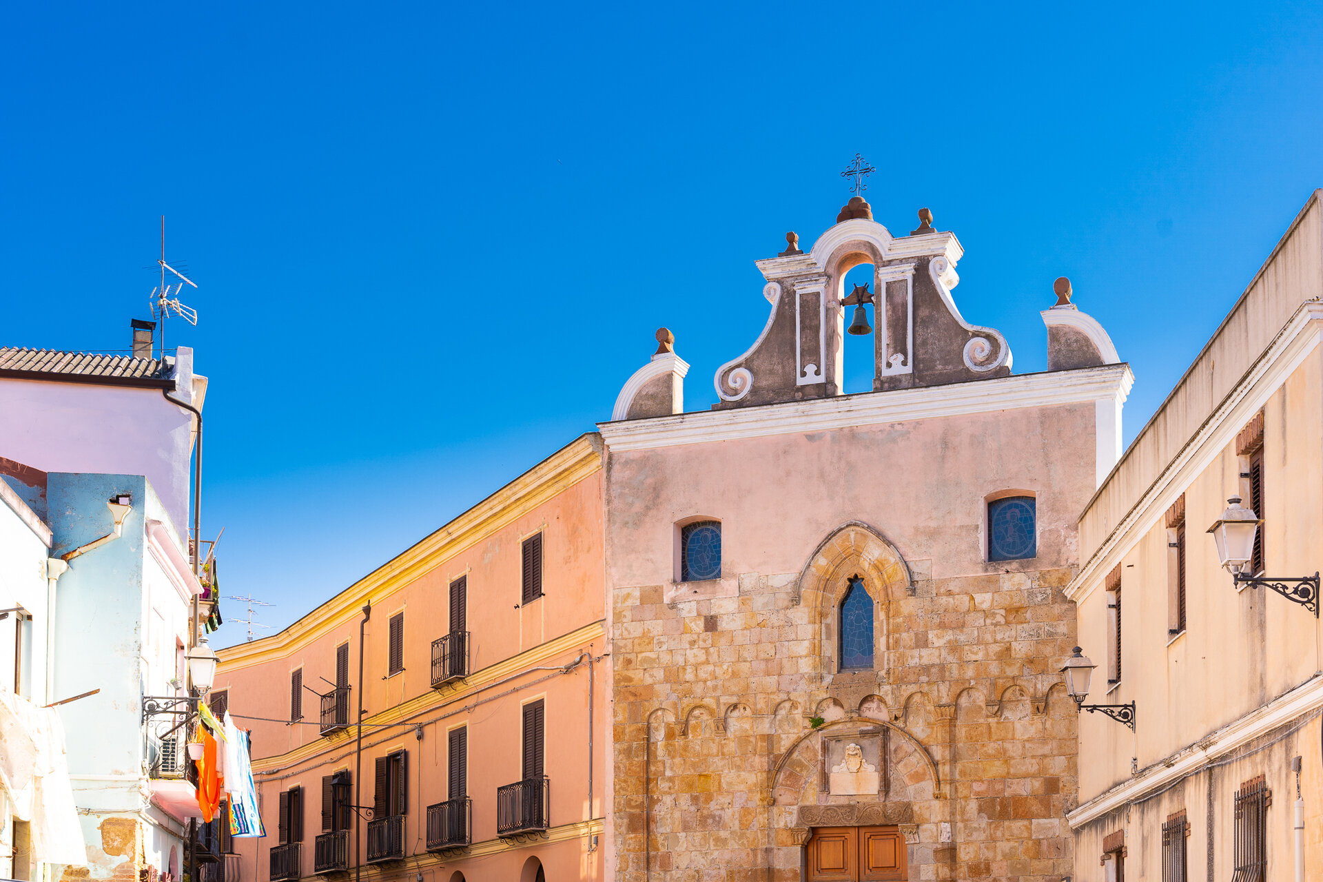 Facciata di una chiesa storica con campanile e cielo azzurro limpido