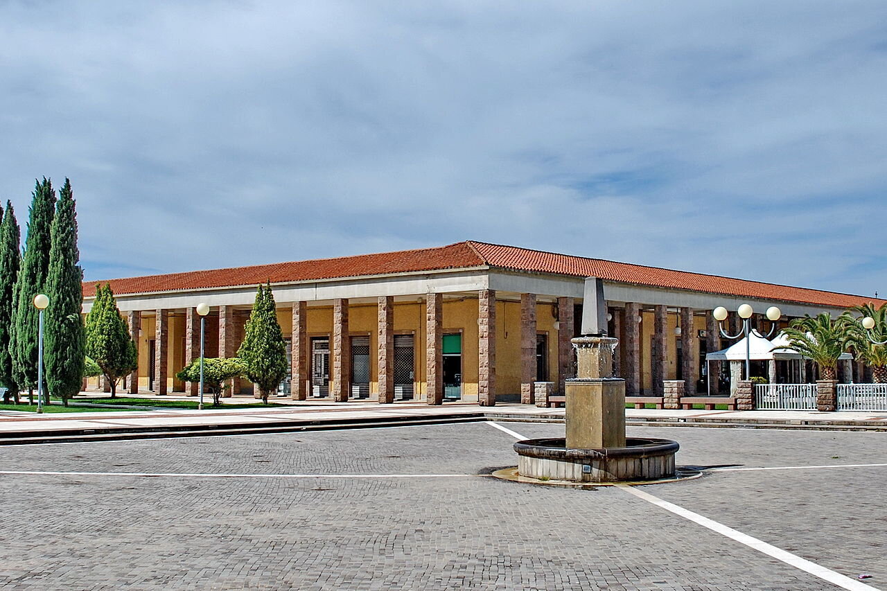 Edificio con colonne e fontana in piazza sotto cielo nuvoloso