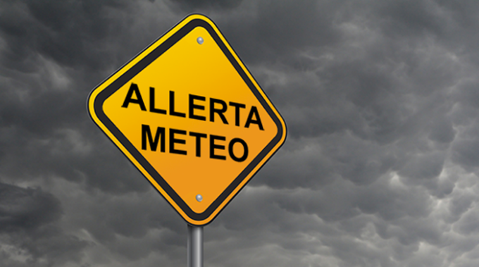 Yellow sign with Weather Alert text against dark cloudy sky