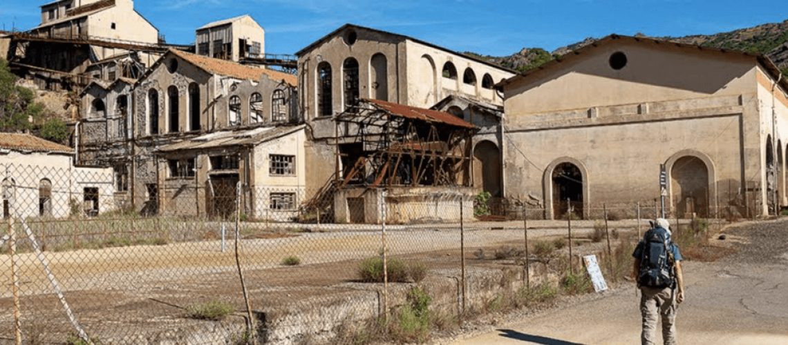 Abandoned industrial buildings with fence and dry vegetation