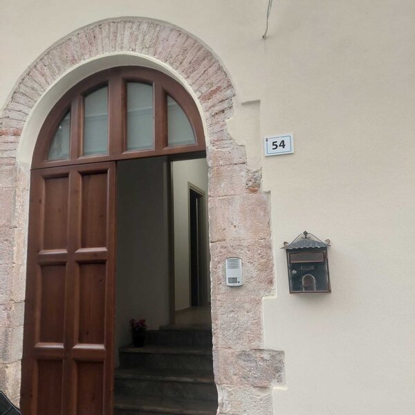 Porta ad arco in legno con campanello e cassetta postale numero 54
