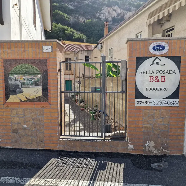 Ingresso con cancello del B&B Bella Posada a Buggeru, con murales e numero civico 58.