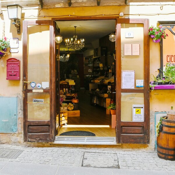 Ingresso aperto di un negozio con prodotti e lampadari visibili all'interno