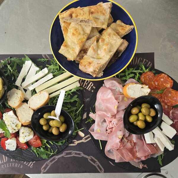 Platter with cold cuts, cheeses, olives, and focaccia in blue bowl