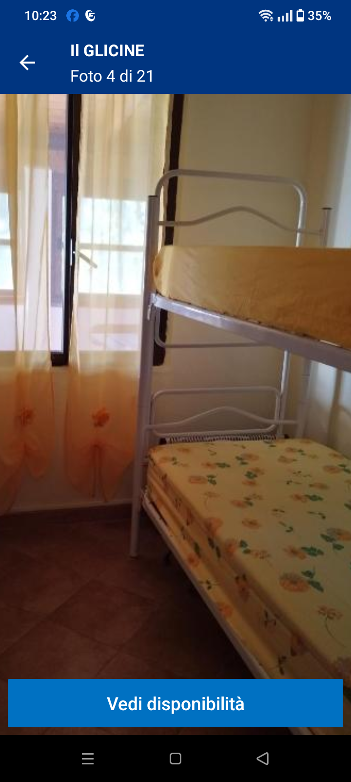 Letto a castello con materassi gialli e tende arancioni in una stanza luminosa