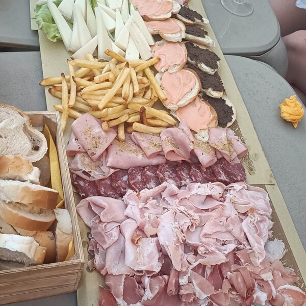 Platter with cold cuts, cheese, French fries, and sliced bread.
